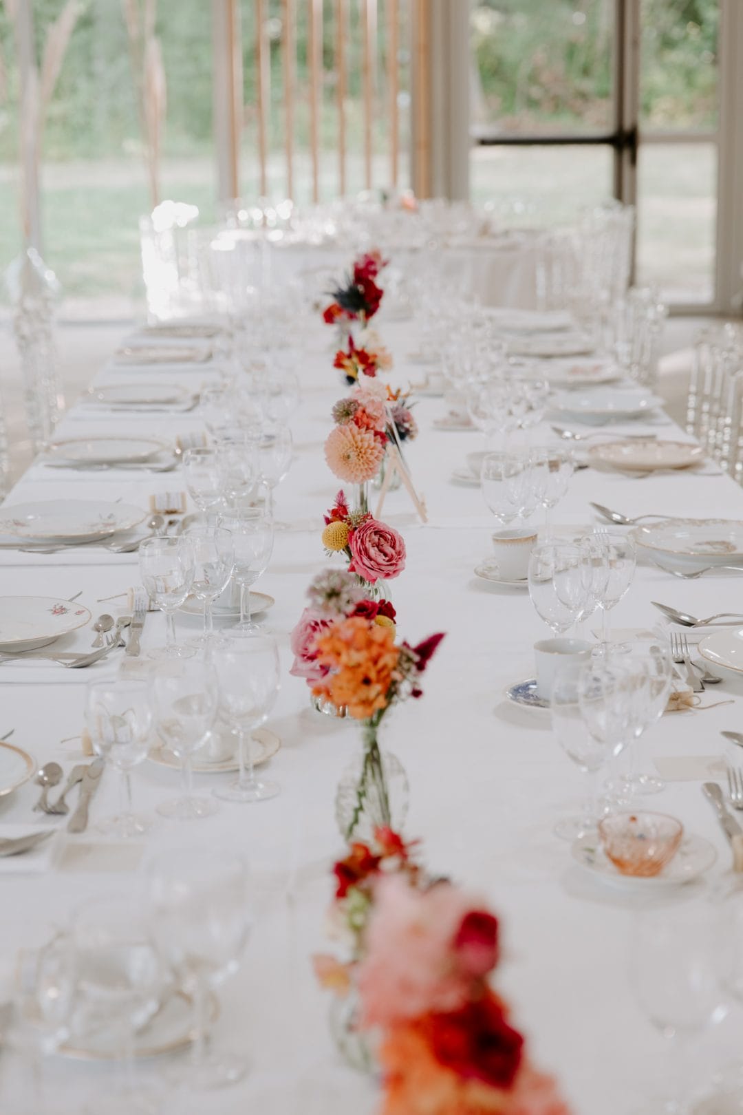 Table décorée avec des fleurs de couleurs vives et originales au centre.